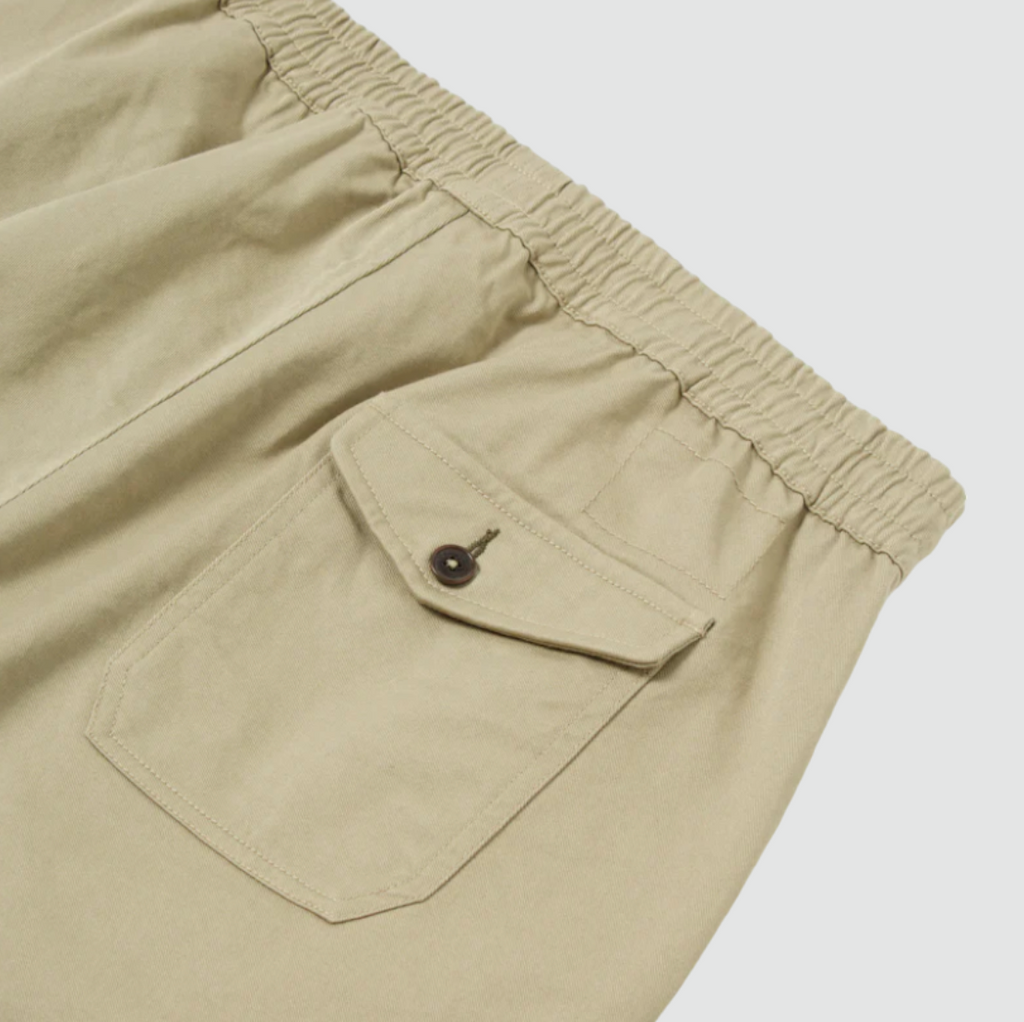 Universal Works Beach Short in Stone Twill - Comfortable above-the-knee short with elasticated drawstring waist. Crafted from exclusive UW fabric in 3/1 twill weave