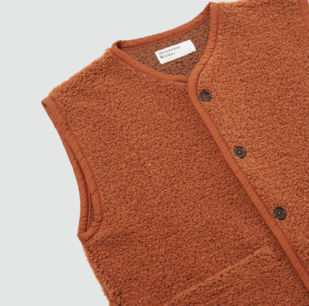 Universal Works Lancaster Gilet Alvar Fleece - Rust: Slim, snug fit with 5-button front, 2 patch pockets, jersey tonal binding. Made from recycled fibers (70% Polyester, 30% Wool)