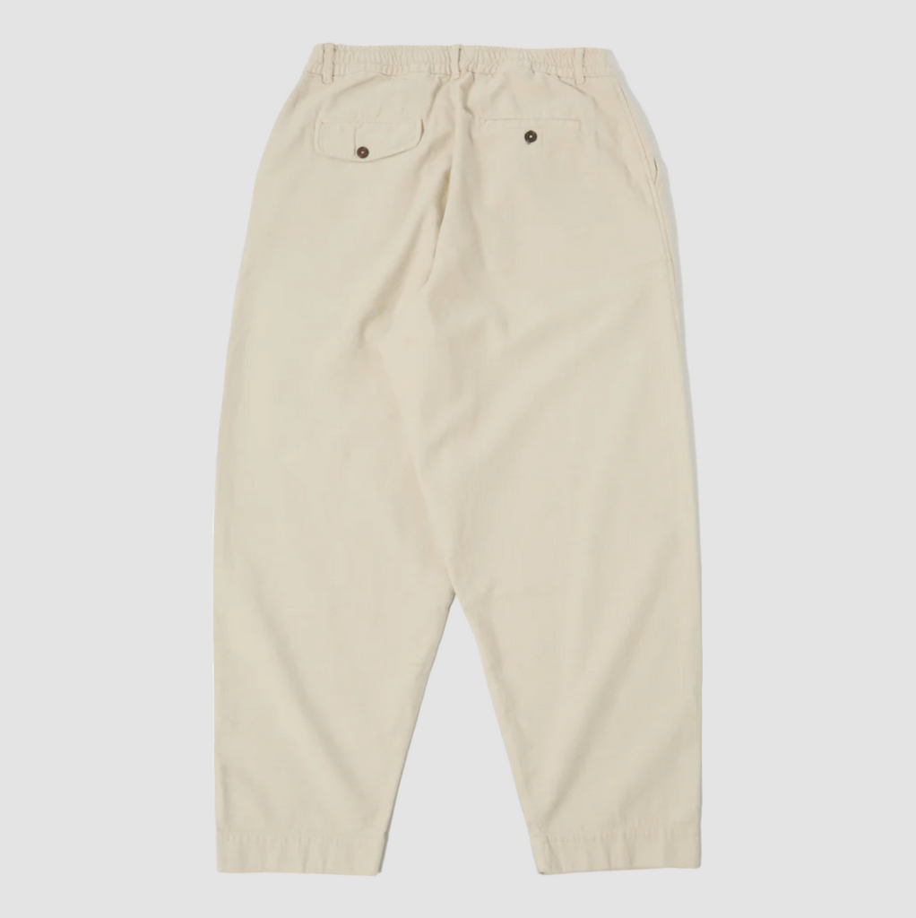 Universal Works Pleated Track Pant in Driftwood Slub Sateen: Loose-fit, tapered leg pant made of 100% cotton. Perfect for summer with its unique texture. Mid-rise with front and rear pockets