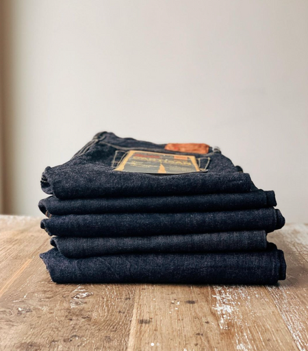 pile of folded jeans that are stocked at Arnold&Co brands such as Momotaro that specialise in Japanese Selvedge Denim