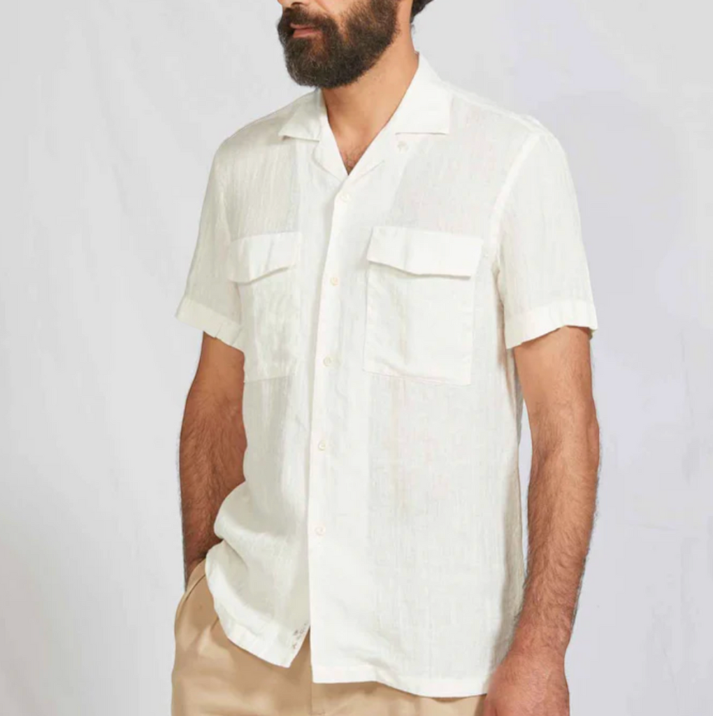 White camp collar shirt made from lightweight Japanese dobby linen with a chest pocket, shell buttons, and embroidered branding.