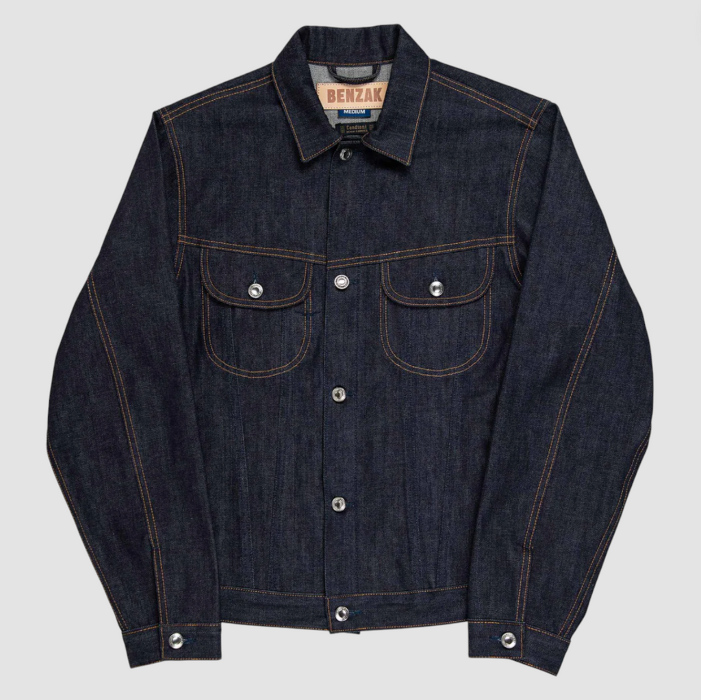 Slim-fit trucker jacket made from raw 15 oz. Italian selvedge denim with chest, hand-warmer, and inside pockets, showcasing vintage style.