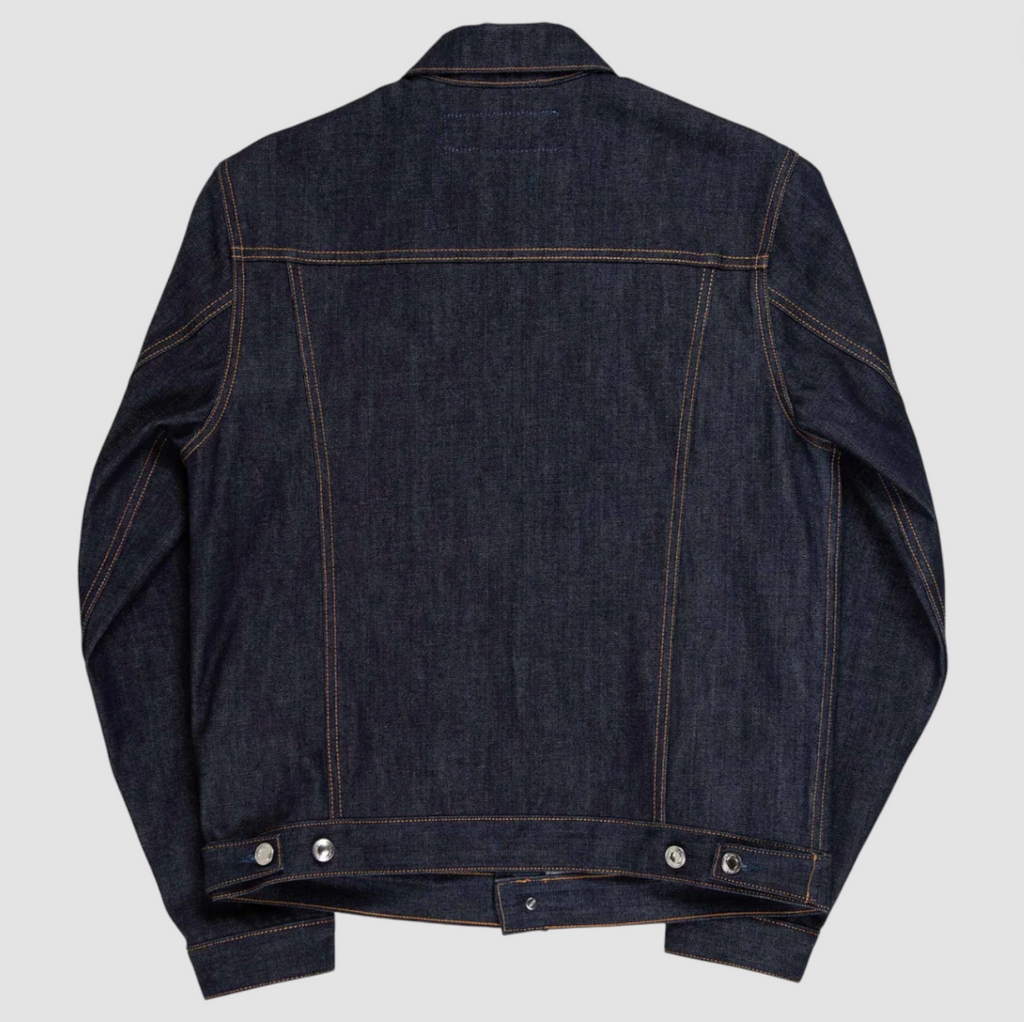 Slim-fit trucker jacket made from raw 15 oz. Italian selvedge denim with chest, hand-warmer, and inside pockets, showcasing vintage style.