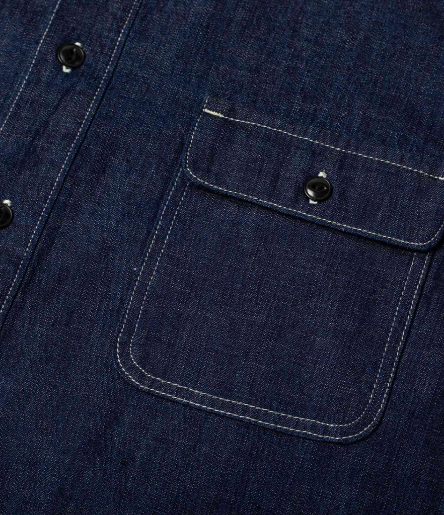 A regular-fit work shirt made from 8 oz. Japanese denim, featuring two chest flap pockets, black overdyed corozo buttons, and heavy-duty stitching.