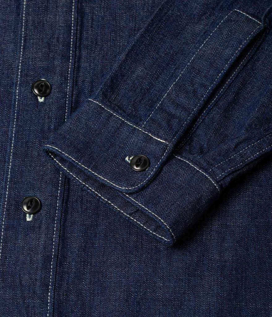 A regular-fit work shirt made from 8 oz. Japanese denim, featuring two chest flap pockets, black overdyed corozo buttons, and heavy-duty stitching.