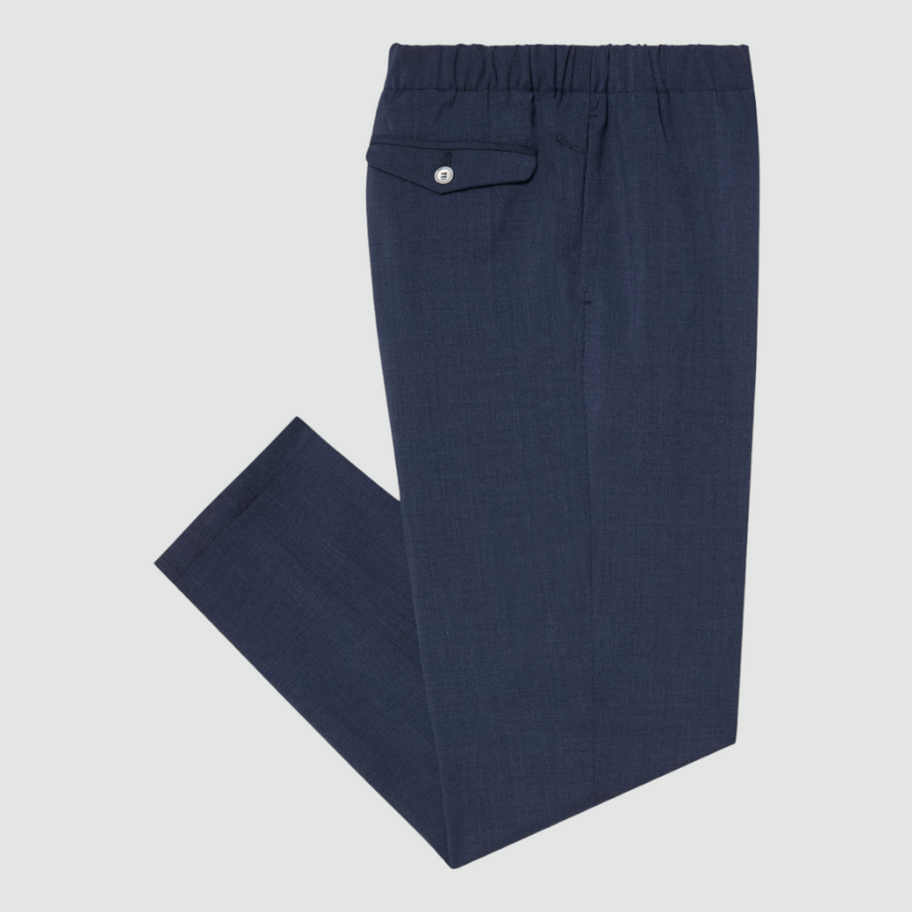 Cruna Burano pants in blue featuring a loose fit, elastic waistband, front and back flap pockets, and an embroidered Cruna logo on the right hip.