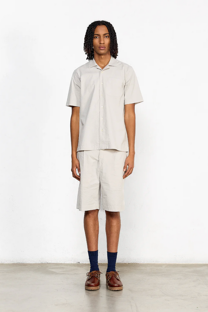 Short sleeve grey seersucker shirt featuring a chest pocket, button front, and relaxed fit with subtle stretch for comfort.