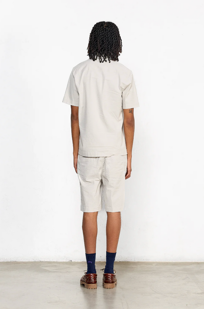 Short sleeve grey seersucker shirt featuring a chest pocket, button front, and relaxed fit with subtle stretch for comfort.