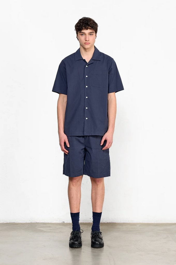 Navy seersucker short sleeve shirt with chest pocket, button front, and relaxed fit, made from cotton with a touch of stretch.