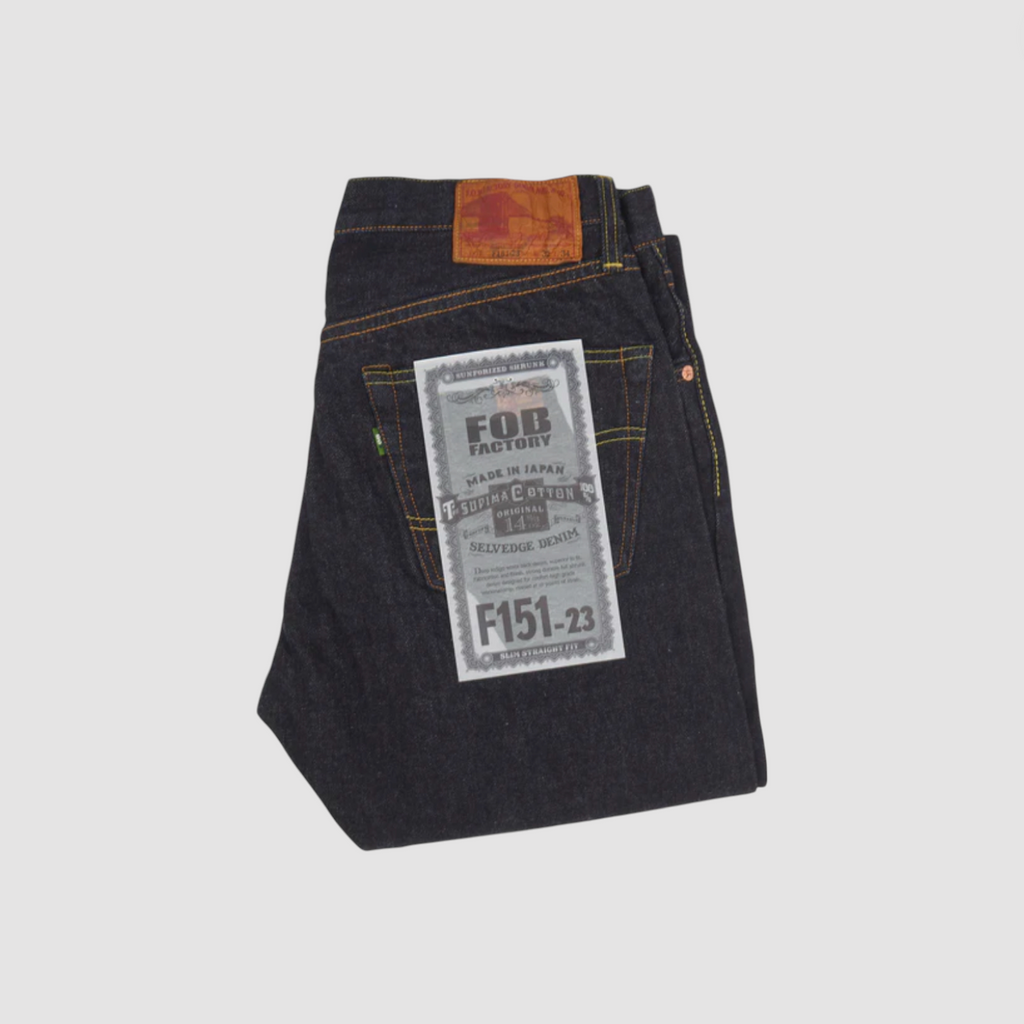 A pair of Japanese selvedge denim jeans on a light grey background.