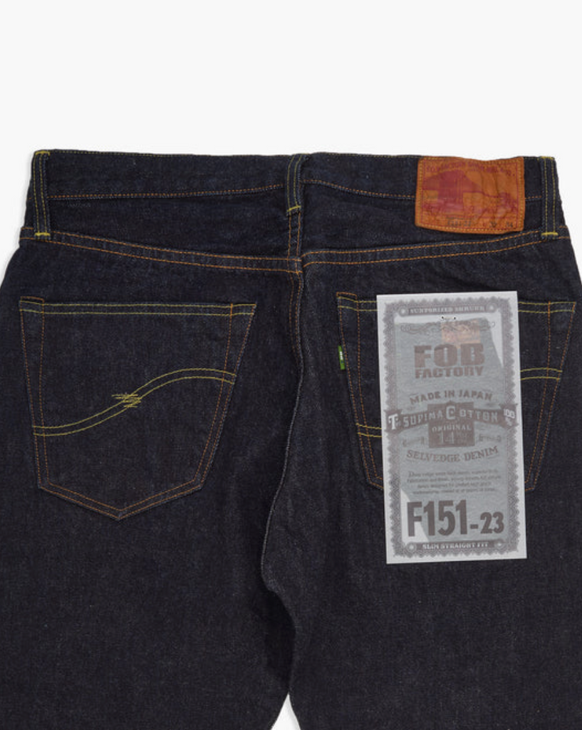 Close up of a pair of Japanese selvedge denim jeans on a light grey background.