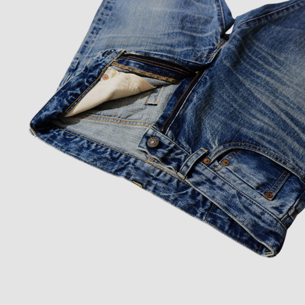 Selvedge denim jeans with a tapered 66 model fit, featuring a vintage-inspired texture, rich indigo fade, and classic workwear heritage.
