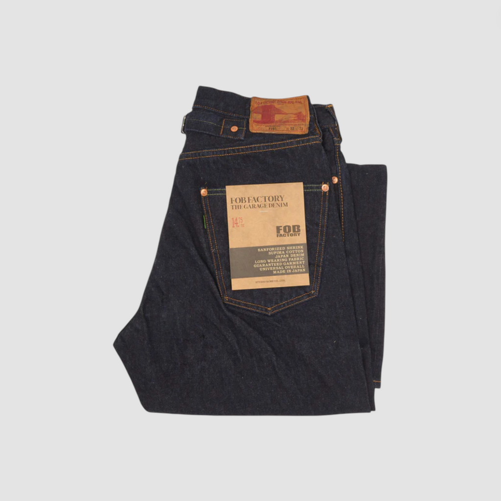 A pair of Japanese selvedge denim jeans on a light grey background.