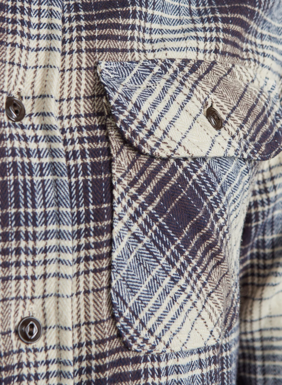 Close up of a navy and ecru checkered shirt.