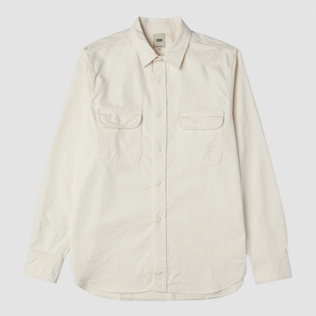 Ecru button up shirt on a light grey background. 