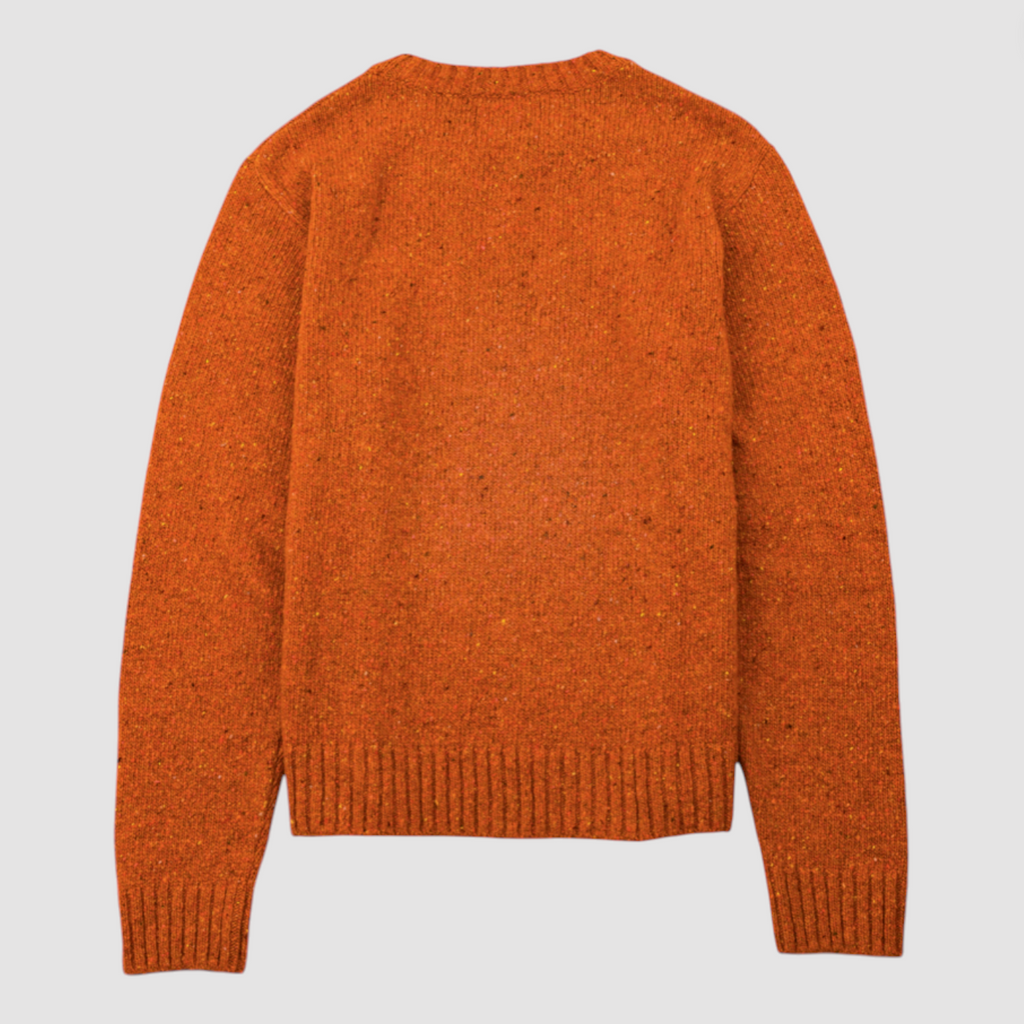 Orange knitted sweater on a light gray background.