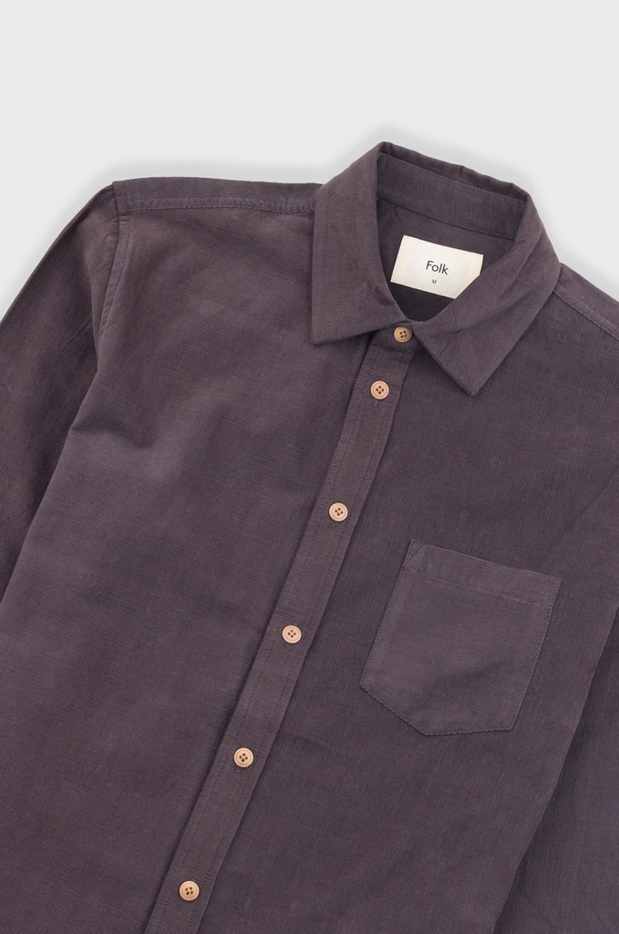 Dark purple shirt with a collar and button details on a light gray background.