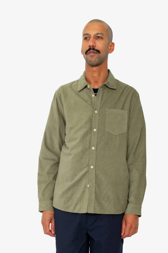 Man wearing a green button-up shirt on a white background.