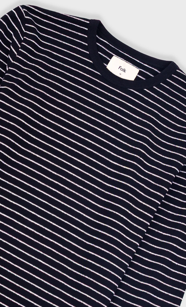 Black and white striped shirt with a brand label on a light gray background.
