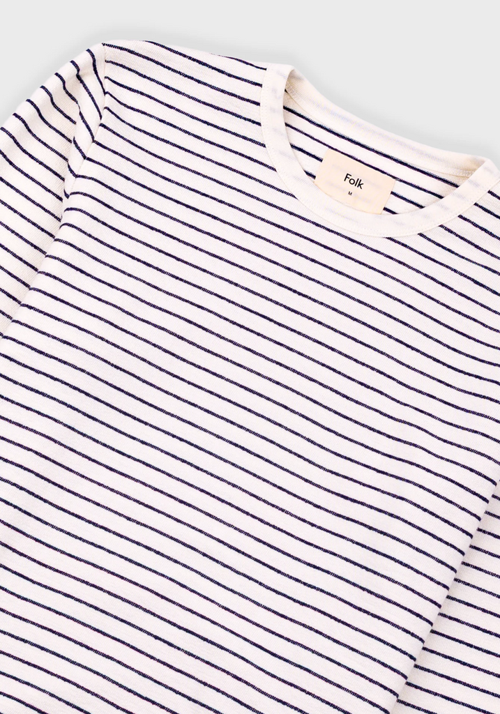 Striped shirt with a brand tag on a light gray background.