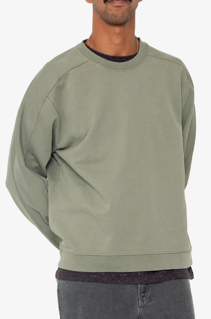 Person wearing a green sweatshirt on a white background.