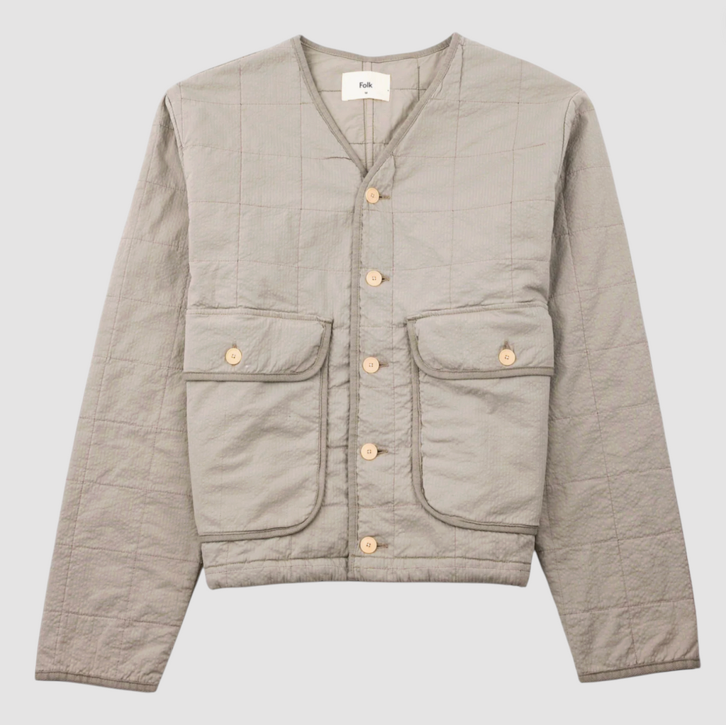 Grey quilted liner jacket on a grey background.