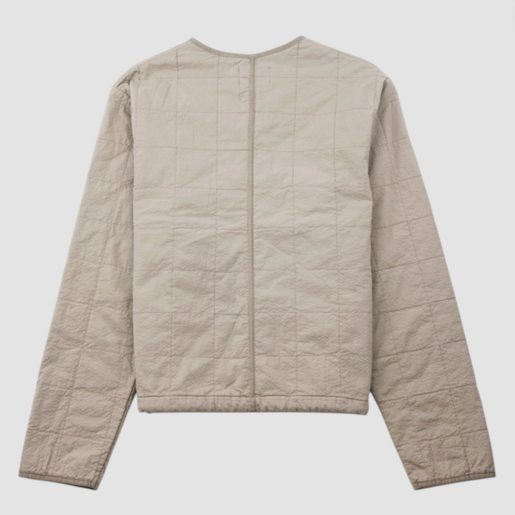 Grey quilted liner jacket on a grey background.