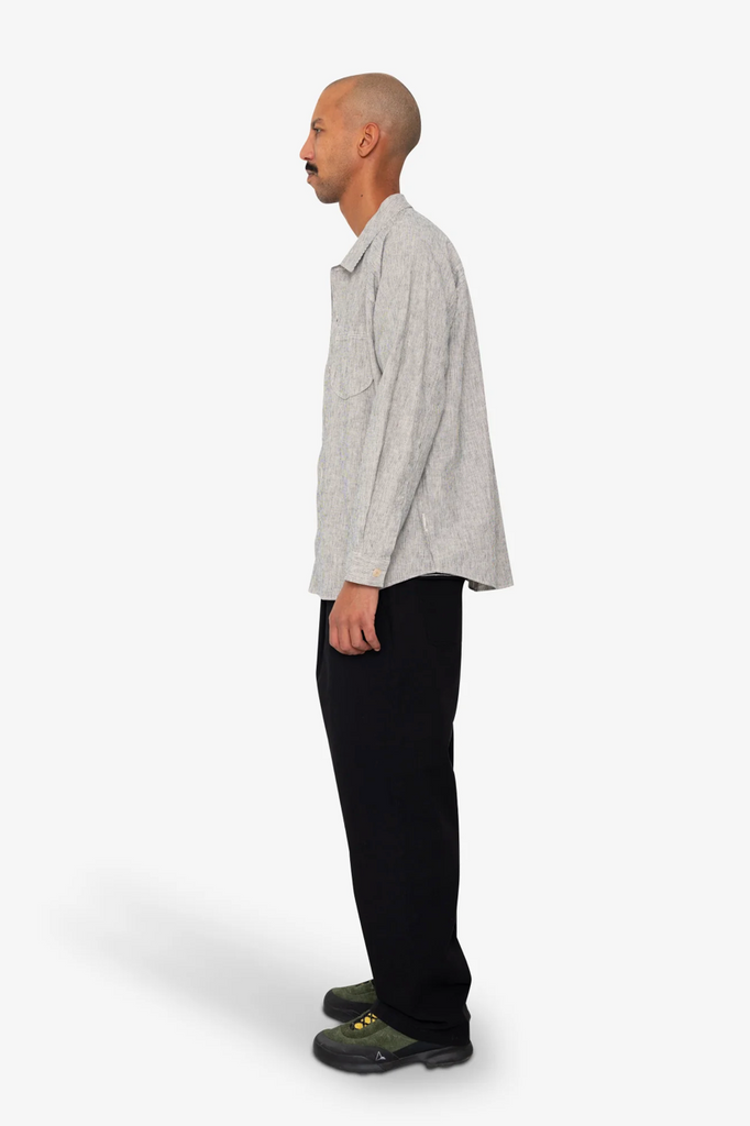 Man wearing a Black and white stripe shirt and black pants on a white background.