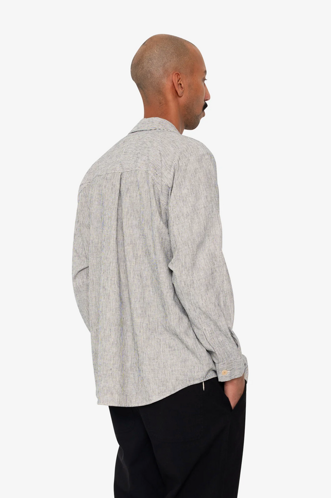 Man wearing a Black and white stripe shirt and black pants on a white background.