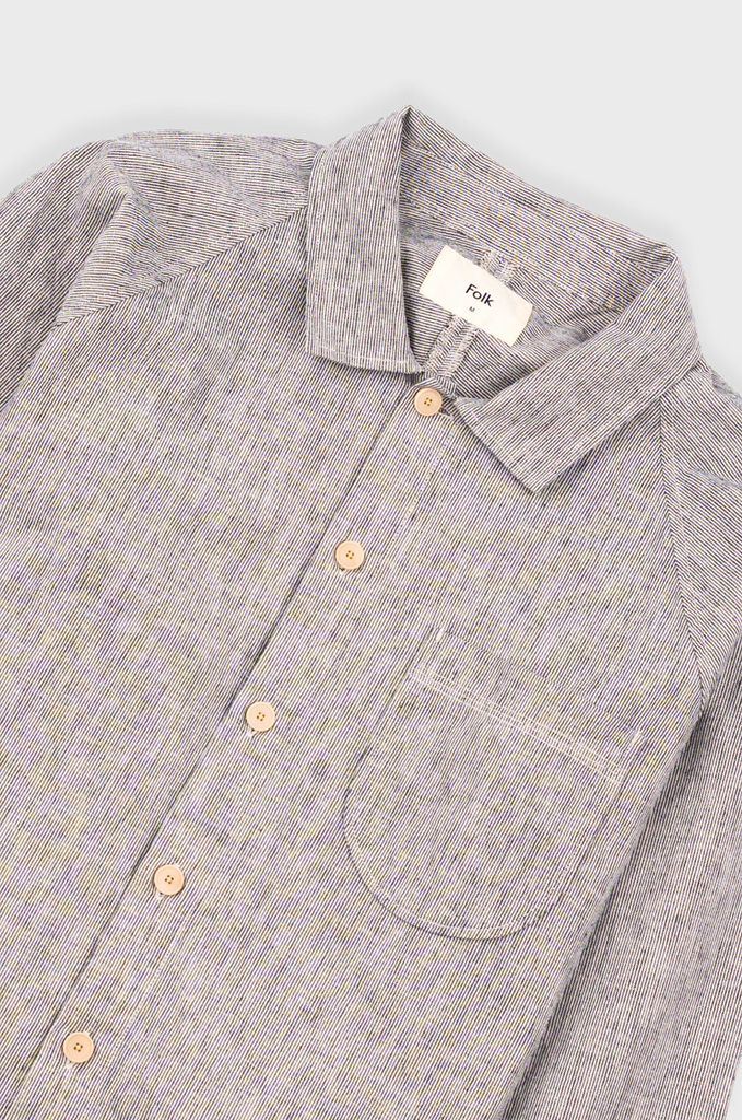 Black and white stripe button-up shirt with a collar and pocket on a light gray background.