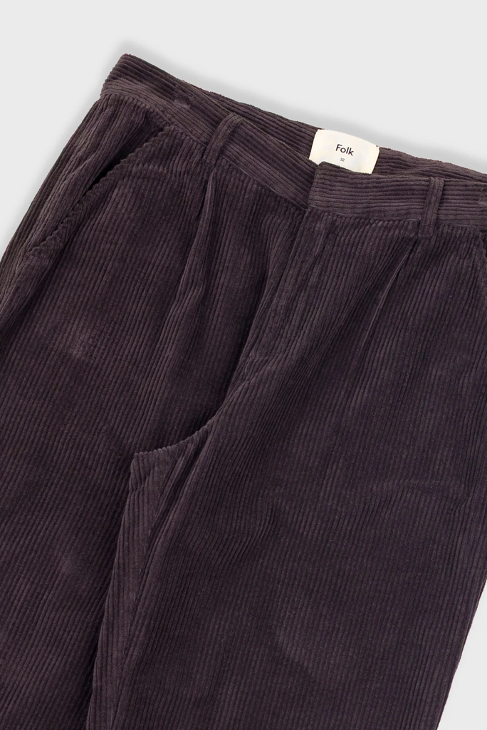 Dark brown corduroy pants with a visible brand label on a light gray background.