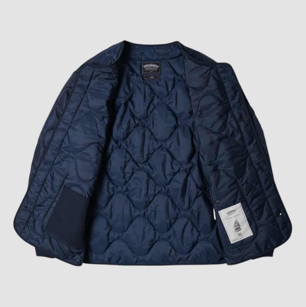 Navy quilted field liner jacket with a 70/30 cotton-nylon blend, lightweight down fill, and military-inspired details. Designed and made in Korea.