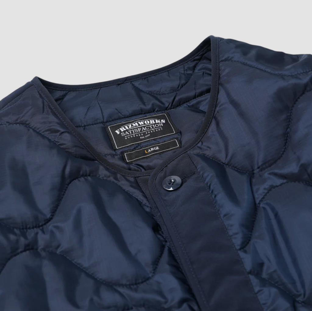 Navy quilted field liner jacket with a 70/30 cotton-nylon blend, lightweight down fill, and military-inspired details. Designed and made in Korea.