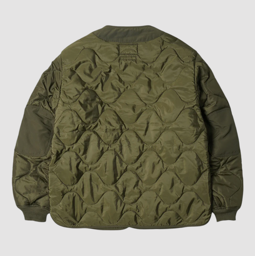 Olive green quilted field liner jacket with a cotton-nylon blend, lightweight down fill, and military-inspired buttons. Designed and made in Korea.