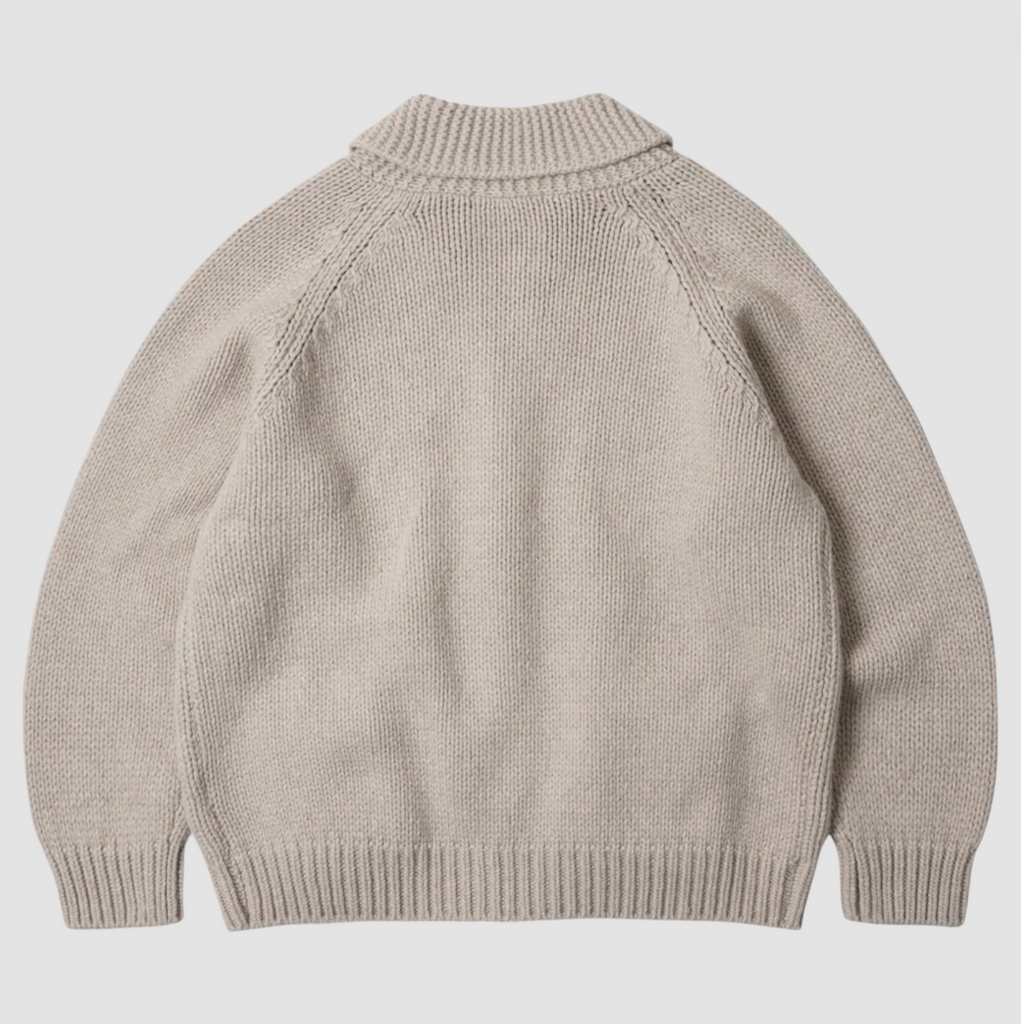 Beige knitted sweater on a light gray background.