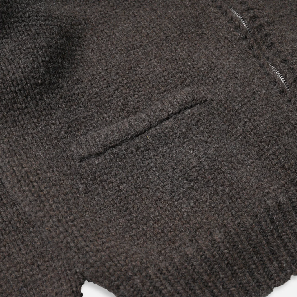 Close-up of a textured brown knitted fabric surface with a pocket.