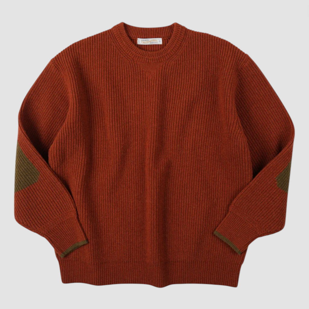 Orange sweater with green accents on a light gray background.
