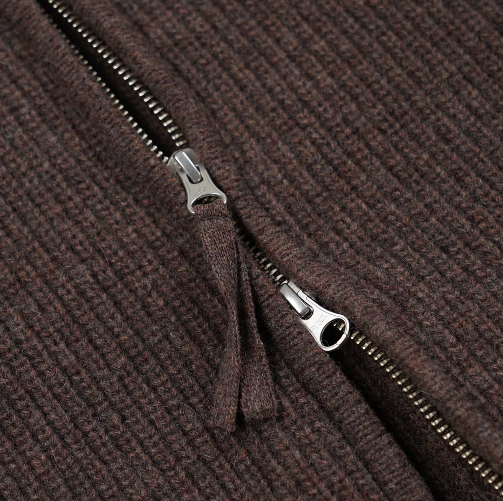 Close-up of a brown textured knit fabric with a zipper.