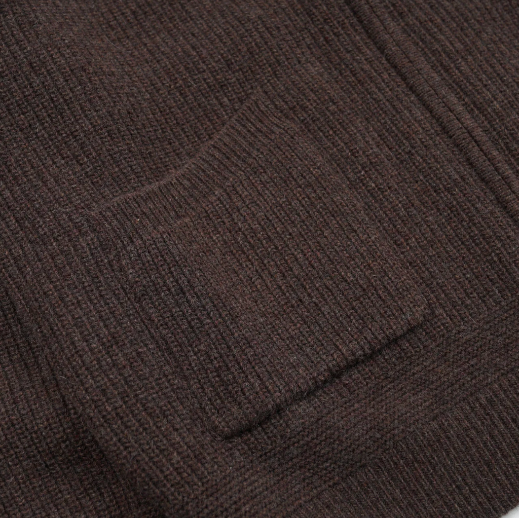 Close-up of a brown textured fabric with a pocket detail.