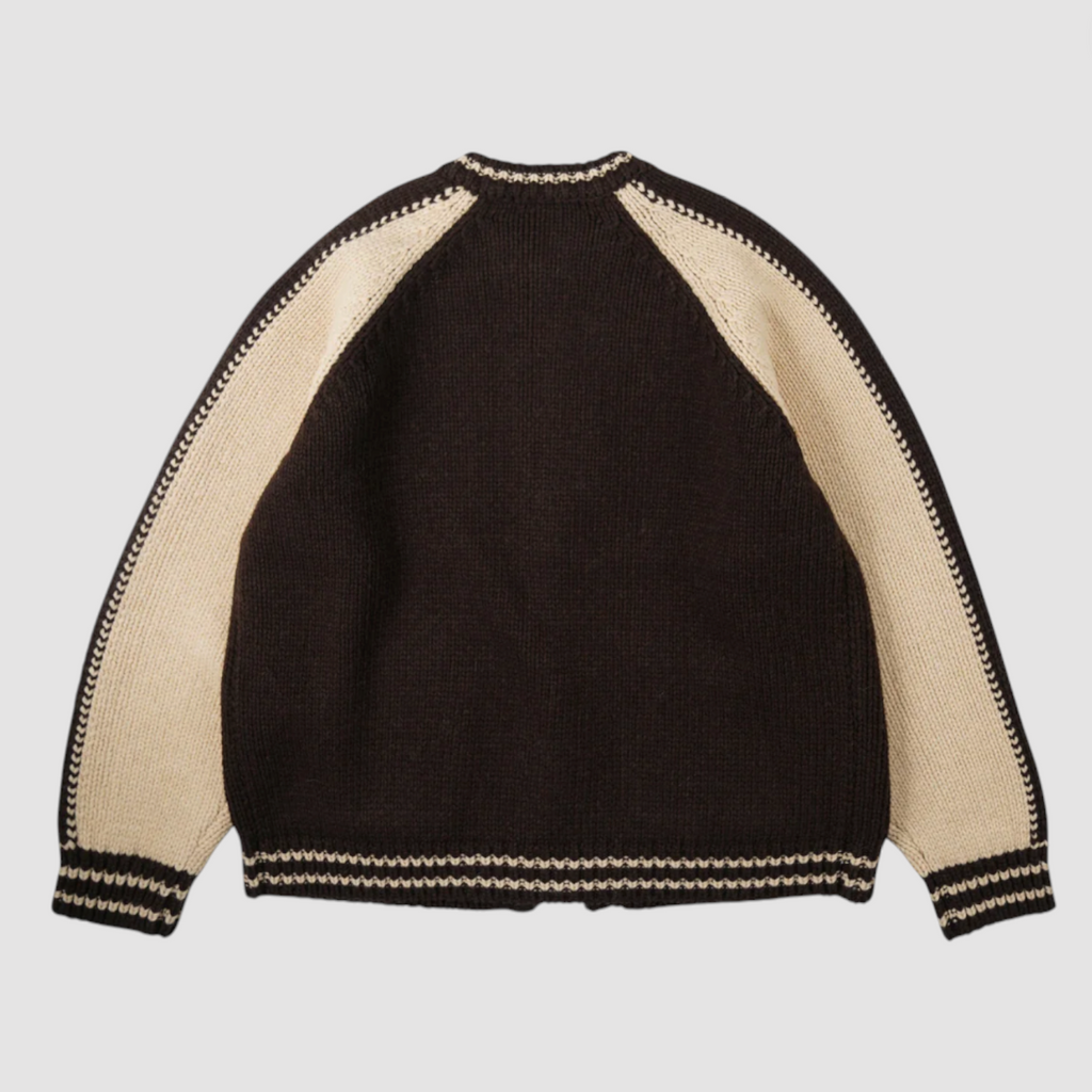 Brown sweater with beige sleeves on a light gray background.