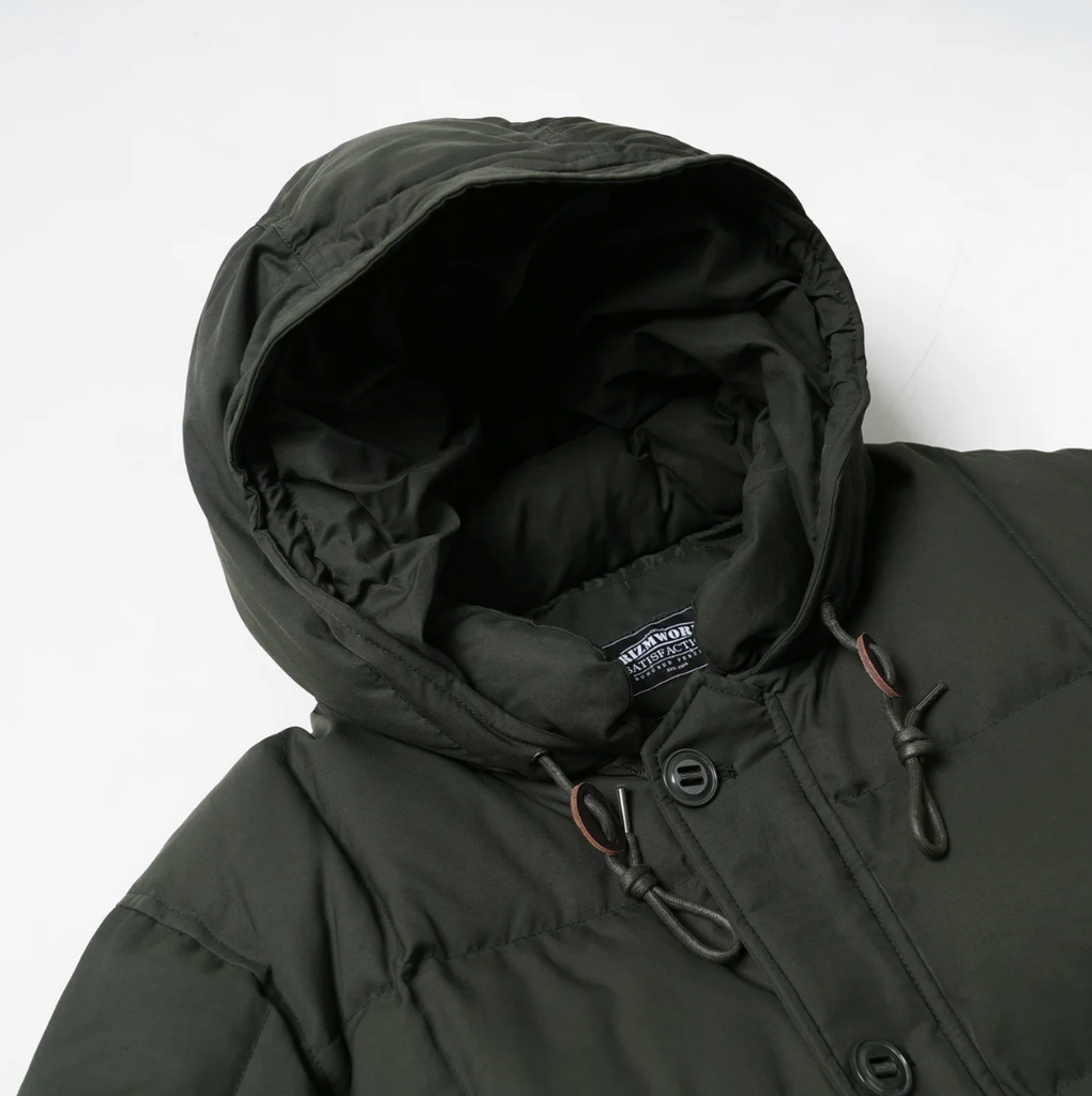 Close-up of a dark green hooded jacket with a brand label on a white background.