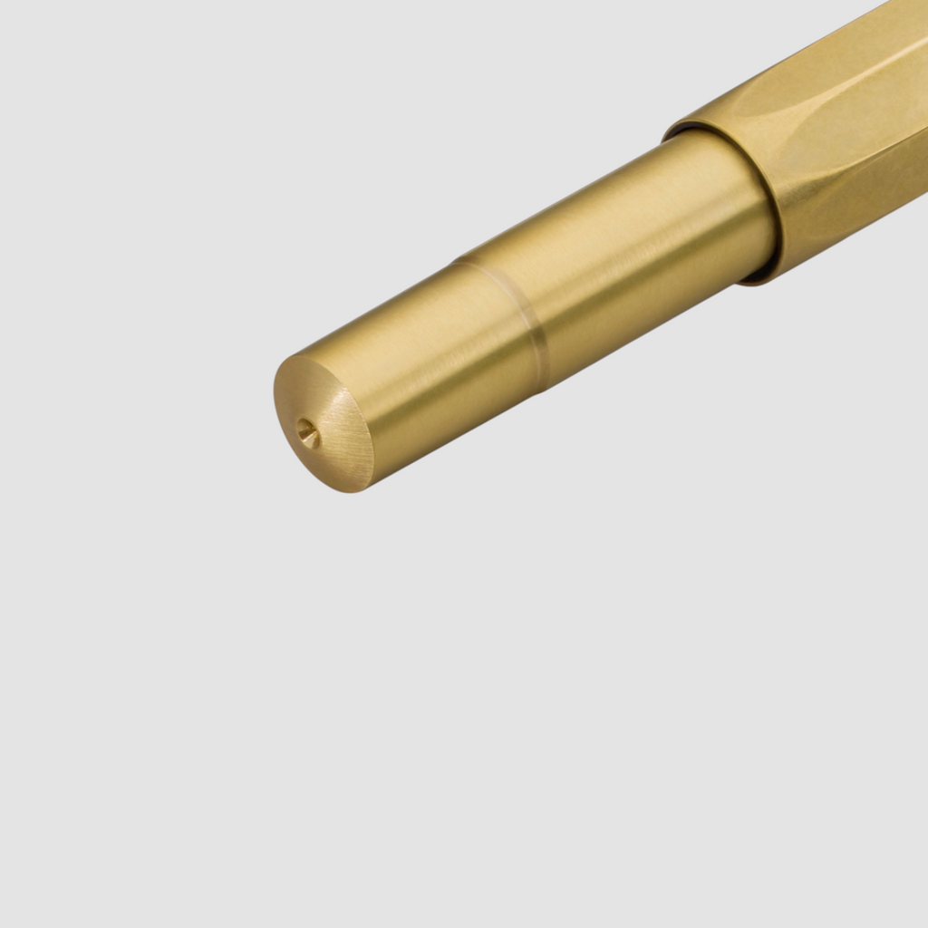 High-quality brass rollerball pen with silver accents, featuring a compact design, smooth writing, and natural patina development over time.