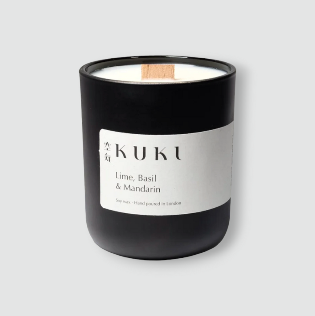 Hand-poured candle with Sicilian lime, basil, and mandarin fragrance in a matte black jar, featuring a wooden wick and 50-hour burn time.