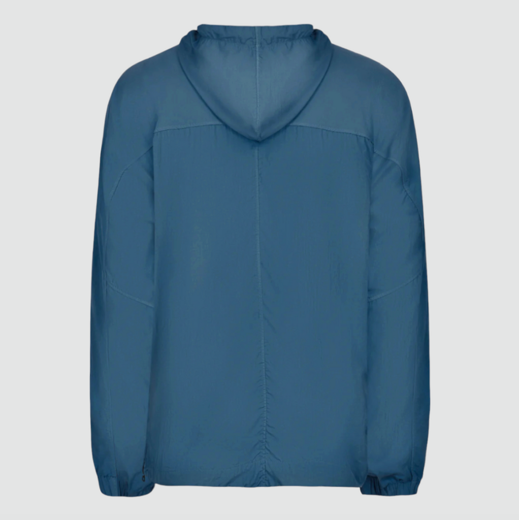 Left Hand Adda Smock in Mid Blue, featuring a recycled nylon canvas, worn-look dye treatment, adjustable hood, 3D chest pocket, and eco-friendly design details.