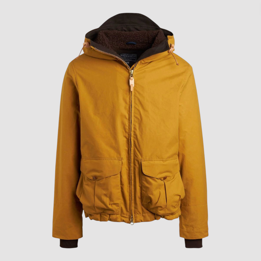 Yellow wax jacket with hood and zip fastenings on a light grey background.