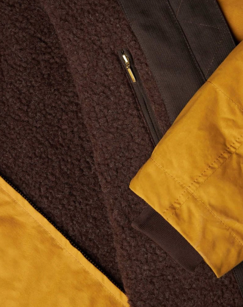 Close up of a yellow wax jacket with a brown wool lining.