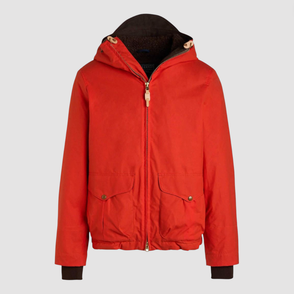 Orange wax coat with hood and zip fastenings on light grey background.