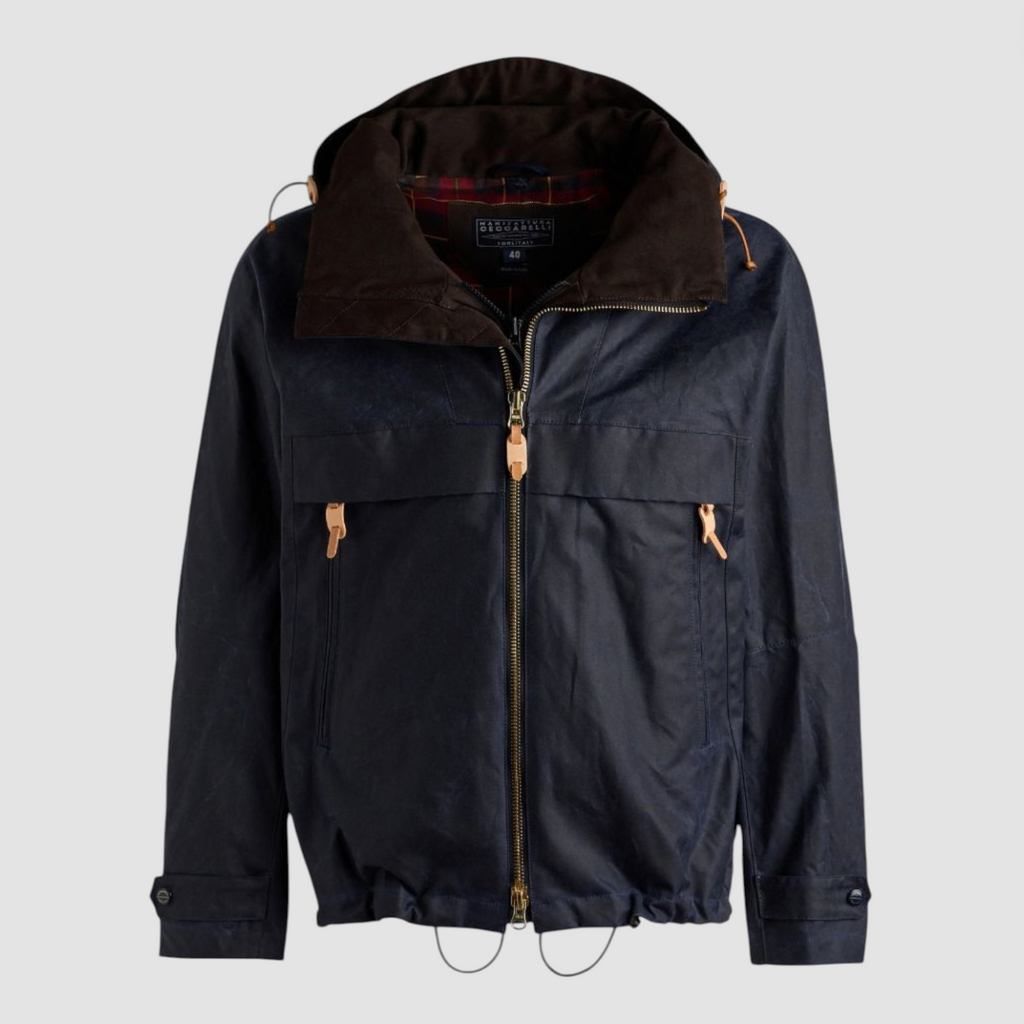 Navy wax jacket with hood and zip fastenings on a light grey background. 