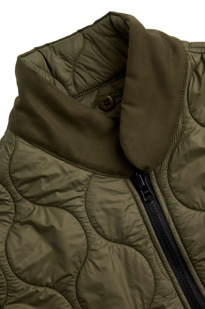 Close up of a green liner jacket on a light grey background.