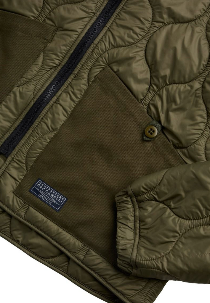 Close up of a green liner jacket on a light grey background.